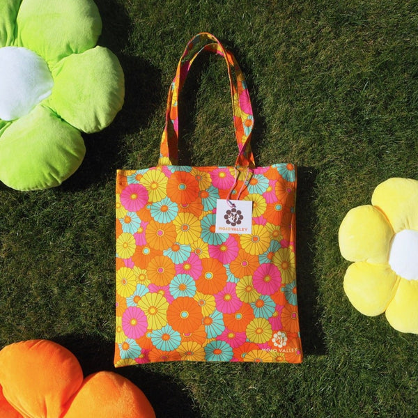 Cotton rainbow floral patterned tote bag in the colours pink, yellow, orange, blue and green 