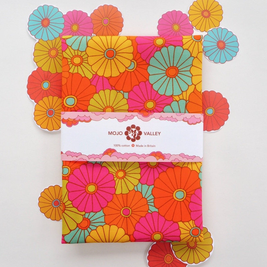 A floral rainbow patterned tea towel in the colours pink, orange, yellow, green and blue